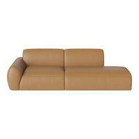 Tan leather sectional sofa with smooth, seamless design and rounded armrest for modern elegance.