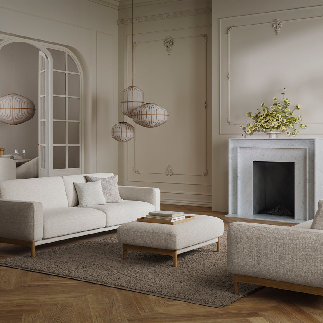 Neutral-toned living room with white sofas, beige accents, and a textured rug, featuring soft, modern patterns.
