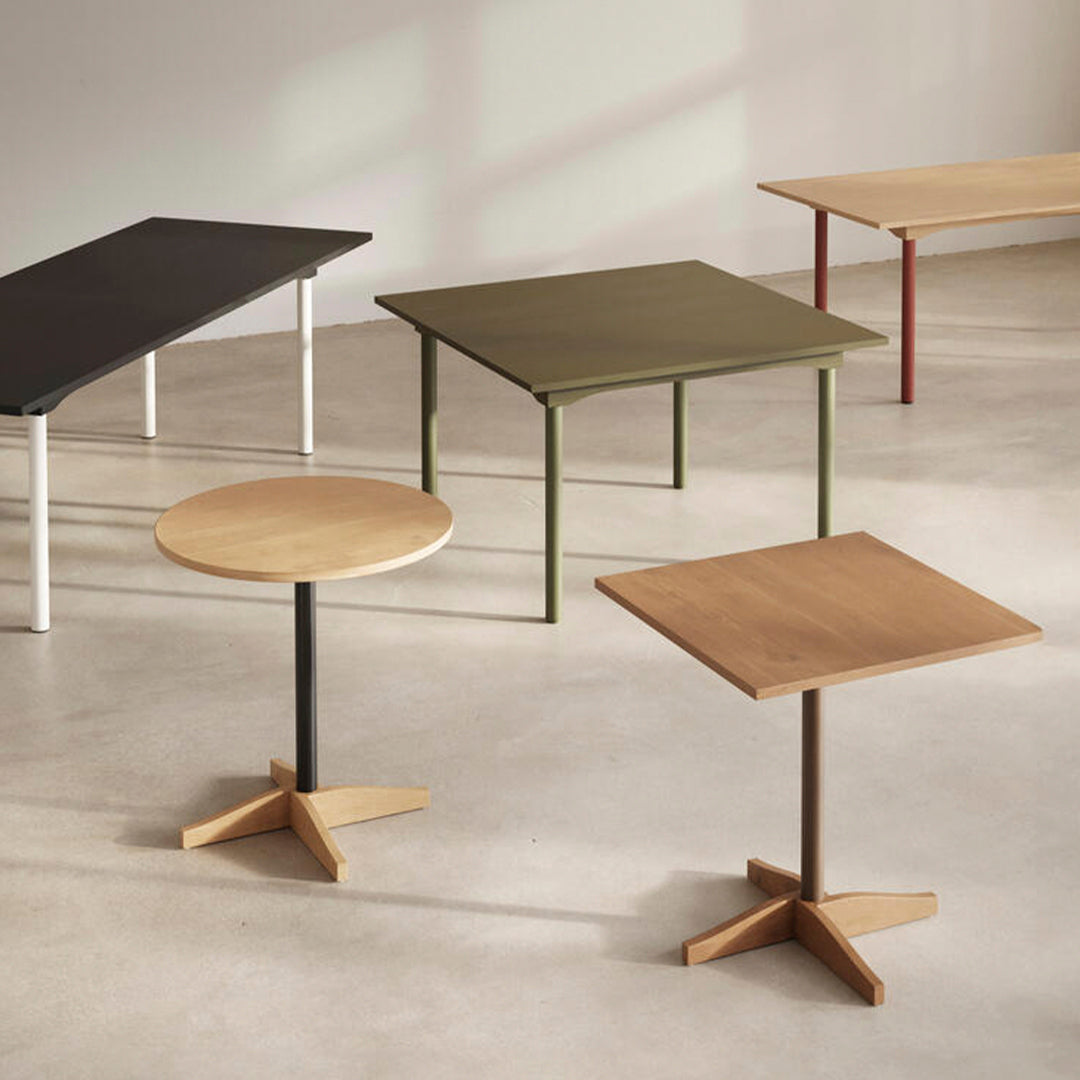 "Modern tables featuring black, green, natural wood, and red finishes with minimalist designs."