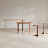 "Wooden tables with minimalist design, featuring earthy tones of brown, green, and red legs, modern geometric shapes."