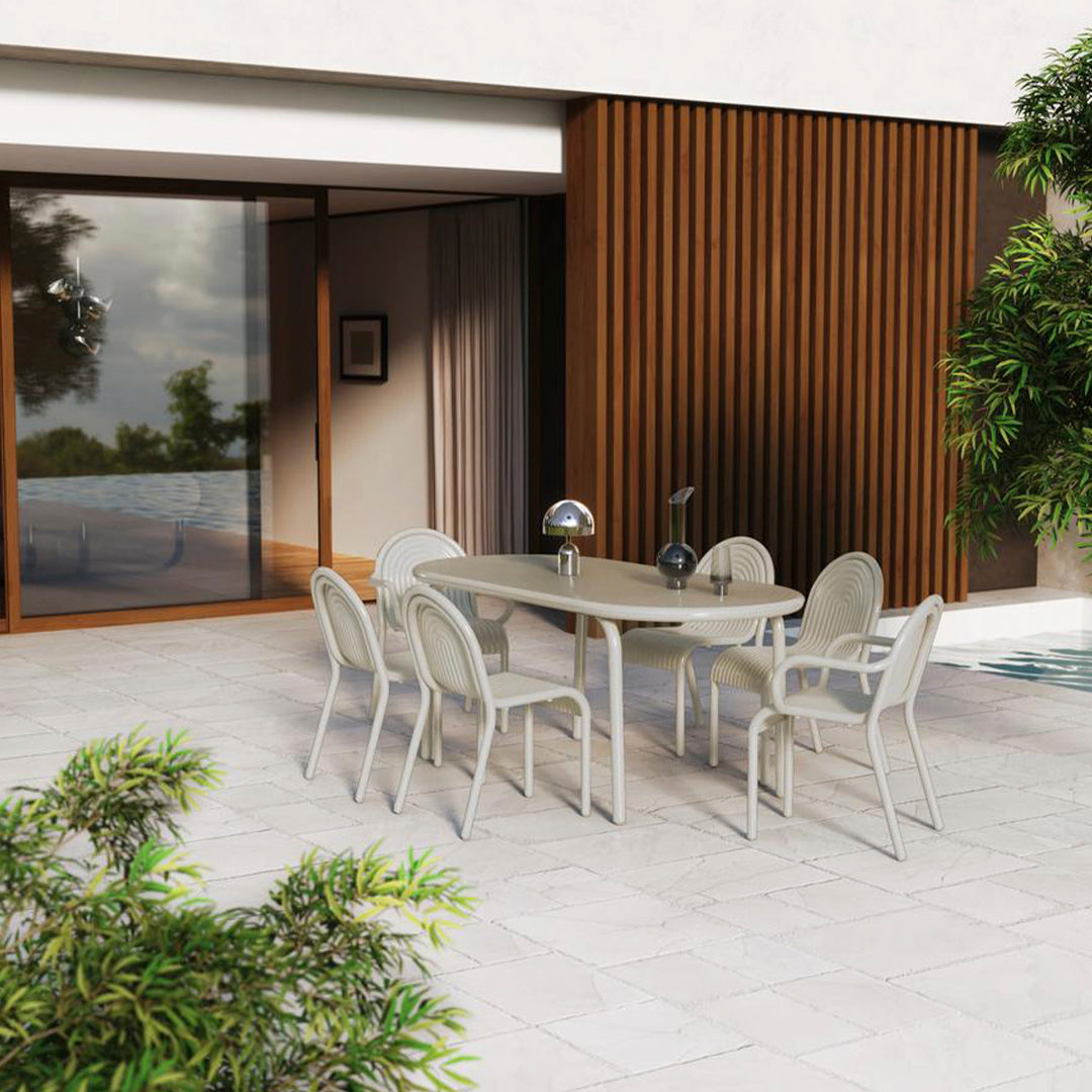Outdoor dining set featuring light gray table and chairs, complemented by warm wood accents and natural greenery.