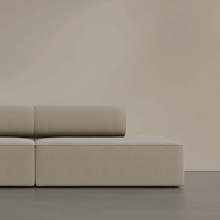 Beige modern sofa with a smooth texture against a soft, neutral background. Stylish and minimalist design.
