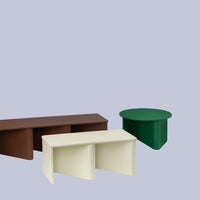 Three modern tables in brown, cream, and green against a soft gray background, showcasing minimalist design and vibrant colors.
