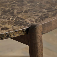 Close-up of a brown marble table surface with earthy tones and unique veining pattern, paired with a wooden edge.