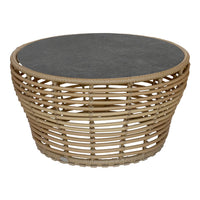 Natural wicker coffee table with a dark gray stone top and a woven, circular design. Ideal for modern decor.