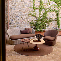 Cozy outdoor seating set featuring earthy brown tones and textured patterns against a stone backdrop.