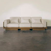 Light beige sofa with clean lines and soft cushions, featuring a modern wooden base and minimalistic design.