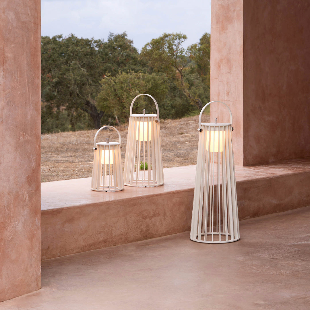"Set of three modern white lanterns with a minimalist striped design, perfect for a warm ambiance."