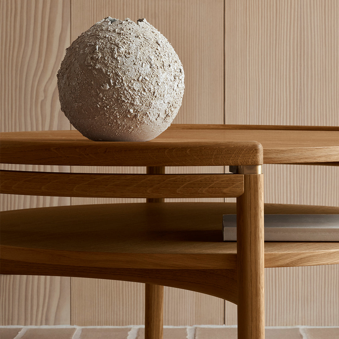 Natural wood tones and textured beige pottery on a minimalist wooden table with subtle linear background.