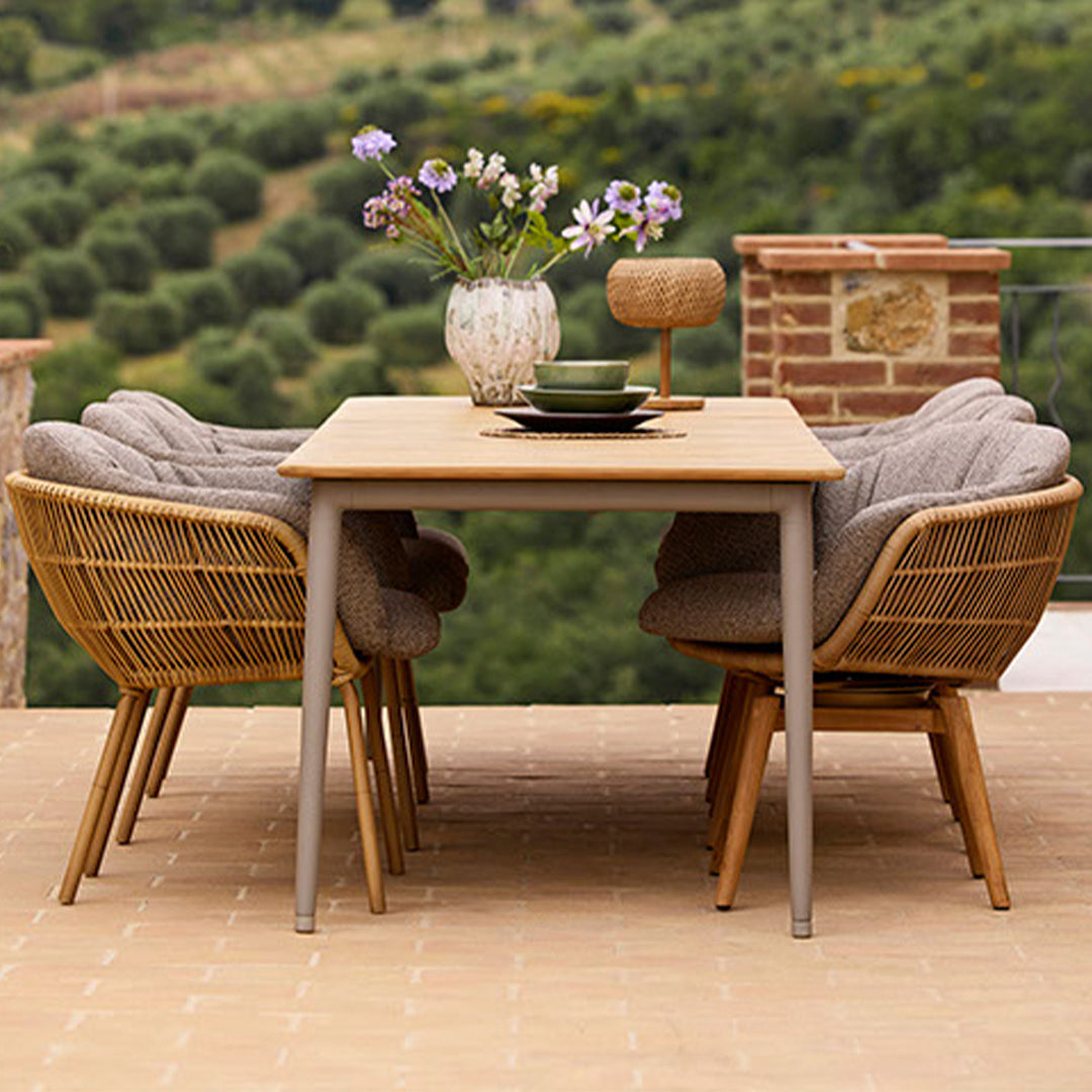 Outdoor dining set featuring beige and gray tones with natural wood textures and elegant floral centerpiece.