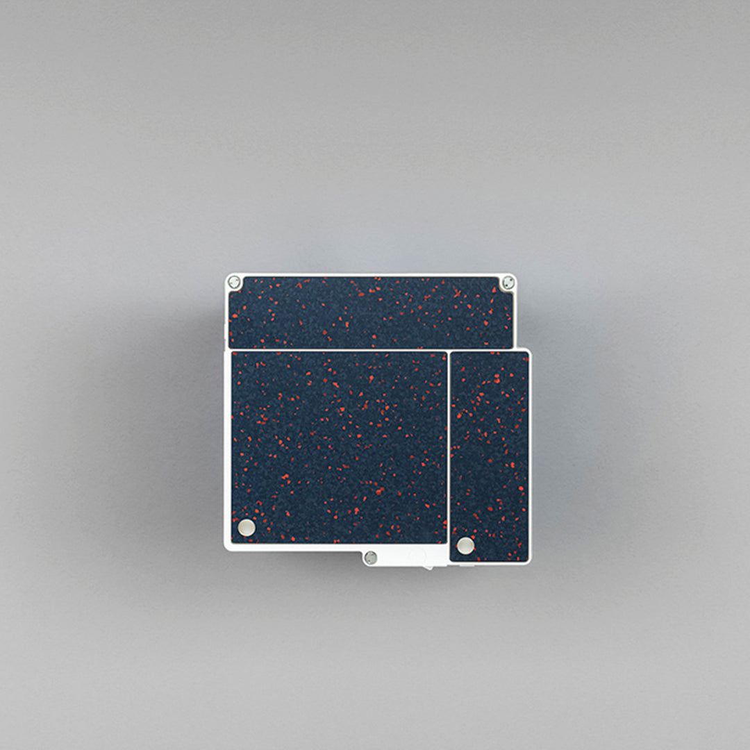 Navy blue surface with red speckles on a white base, featuring a modern, geometric pattern.