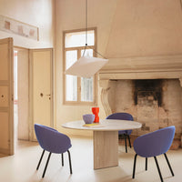 "Elegant interior with soft beige walls, purple chairs, white pendant light, and bold red vase on a round table."