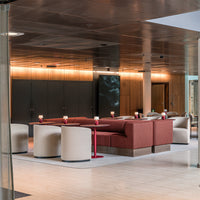 Modern lounge featuring beige and maroon furniture with sleek wood and metal accents in a stylish, contemporary setting.