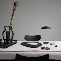 Elegant black and white dining setup featuring geometric patterns and sleek designs on a minimalist table.