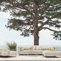 Beige outdoor sectional sofa with subtle fabric texture and minimalist design, set against a serene natural backdrop.