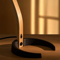 Wooden and black desk lamp base with warm golden shadows creating a cozy atmosphere.