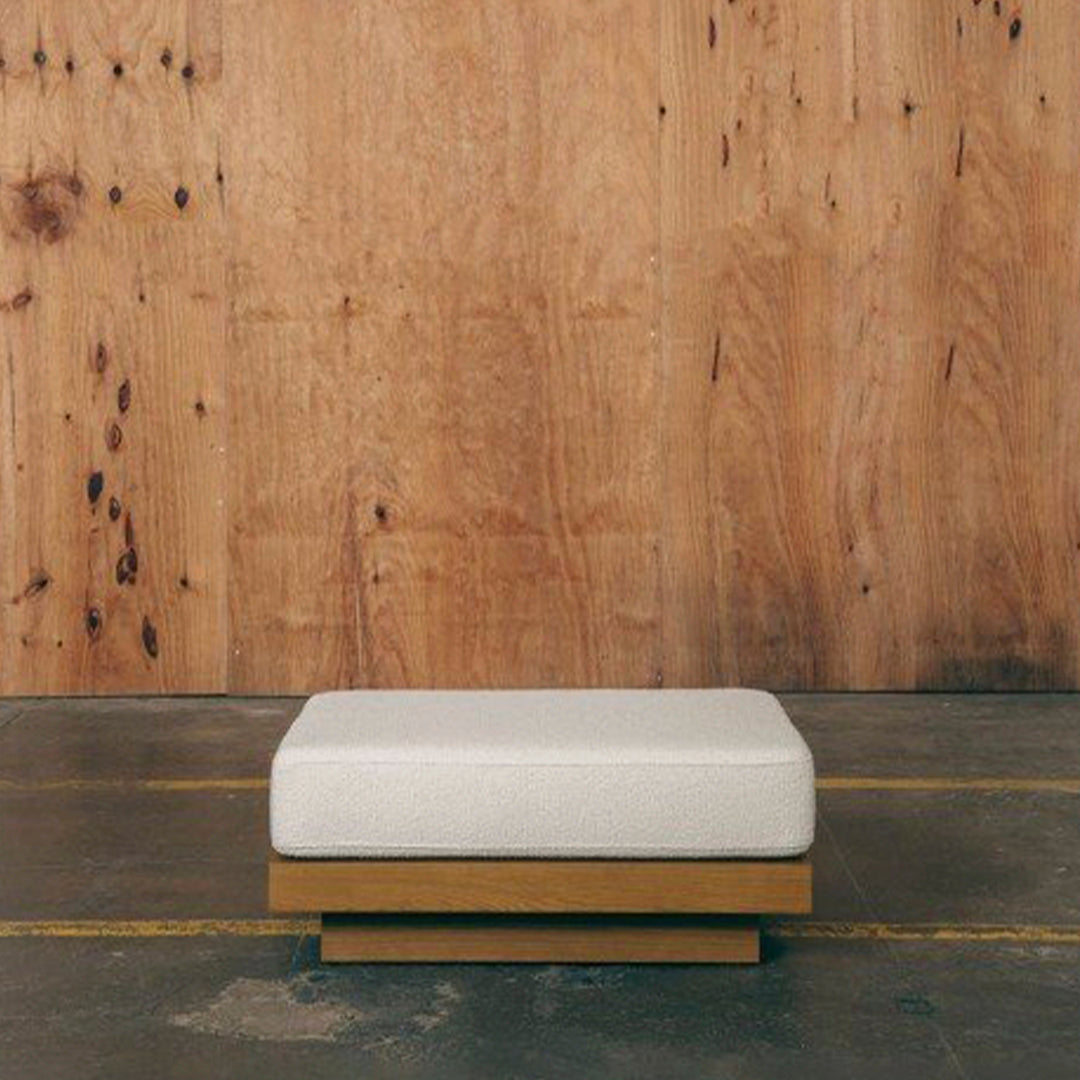 White cushion atop a natural wood base, featuring a minimalist design on a rustic background. Perfect for modern decor.