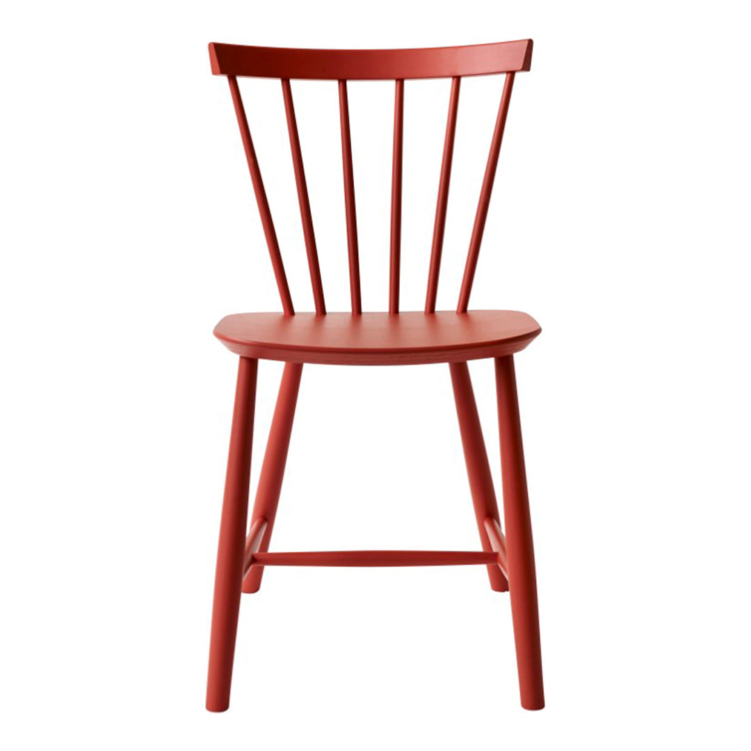 Red wooden chair with a minimalist design and spindled backrest, perfect for modern decor.