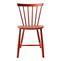 Red wooden chair with a minimalist design and spindled backrest, perfect for modern decor.