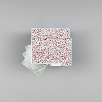 Colorful patterned trays with a vibrant red, white, and speckled design on a smooth gray background. Perfect for decor.
