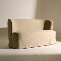 Beige linen slipcovered sofa with soft, minimalist design and rounded arms, perfect for modern living spaces.