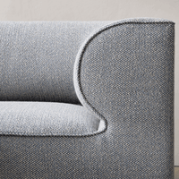 Textured gray fabric sofa with a subtle blue hue. Modern design and soft, intricate woven pattern.