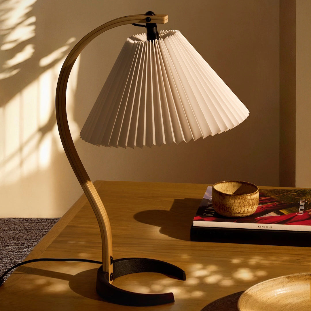 Stylish white pleated lamp shade with a natural wood base, creating a modern aesthetic. Perfect for contemporary decor.