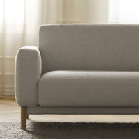 Light gray upholstered sofa with clean lines and wooden legs, set against a soft, neutral background.