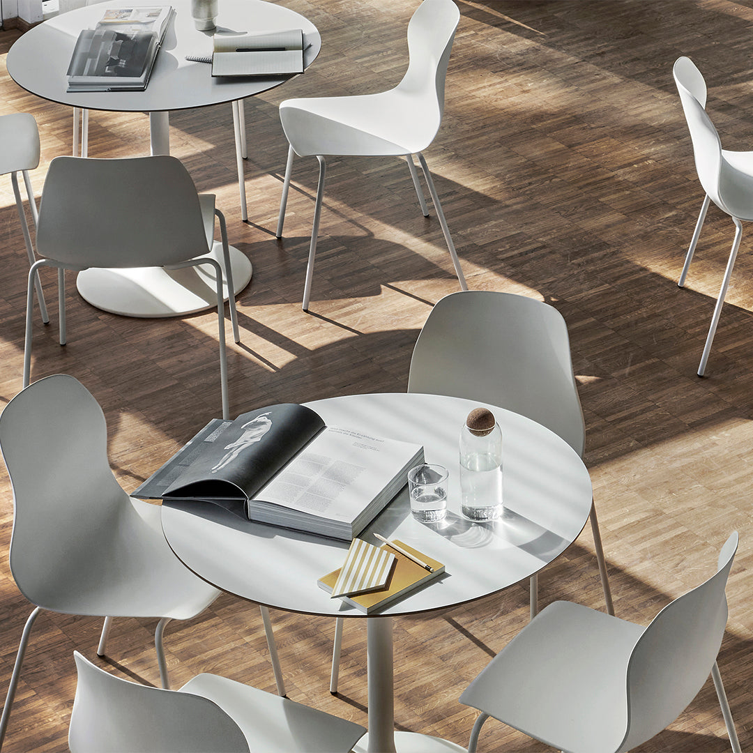 Minimalist white furniture paired with warm wood tones and soft shadows, creating a modern, airy atmosphere.