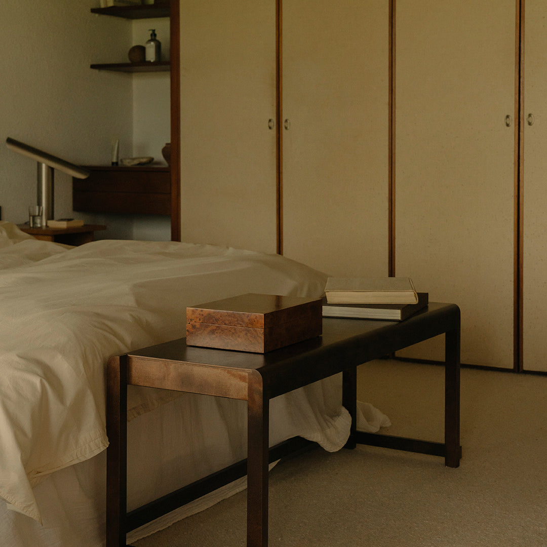 Neutral beige bedding paired with dark wood furniture and light walls, creating a serene, minimalist aesthetic.