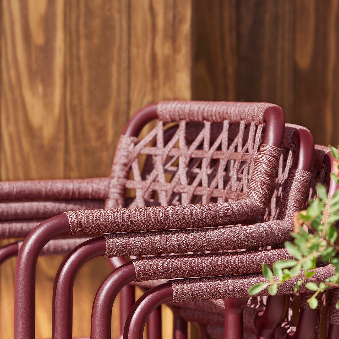 Stylish maroon outdoor chairs with woven detailing and a sleek design, perfect for modern spaces.