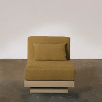 Olive green chaise lounge with a textured fabric and light wood base, featuring a matching rectangular cushion.