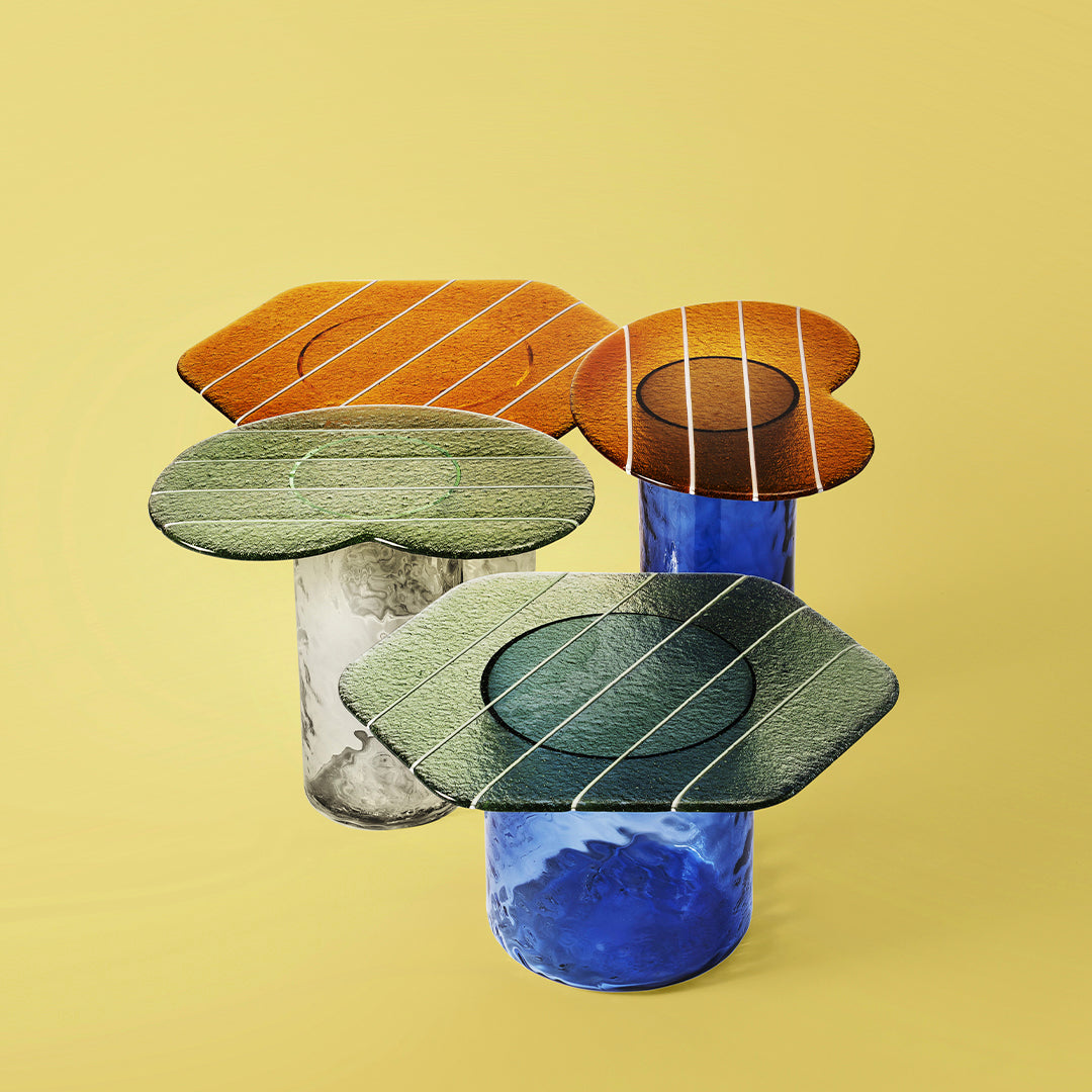 Colorful glass tables with orange, green, and blue patterns, featuring textured surfaces and playful geometric shapes.