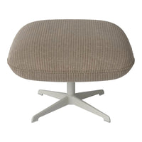Soft beige ottoman with subtle ribbed texture and a sleek white base. Perfect for modern decor.