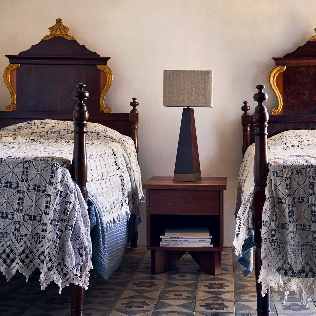 "Elegant white crochet bedspreads with blue accents and intricate geometric tile patterns in a warm, inviting bedroom."