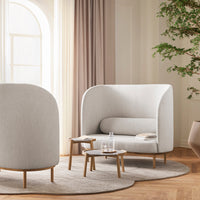 Light gray upholstered seating with smooth curves and a soft texture, complemented by natural wood accents and neutral tones.