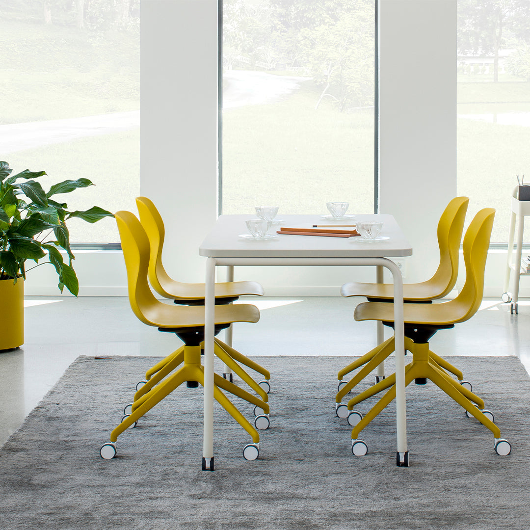 Modern dining set featuring bright yellow chairs and a sleek white table on a soft gray rug.