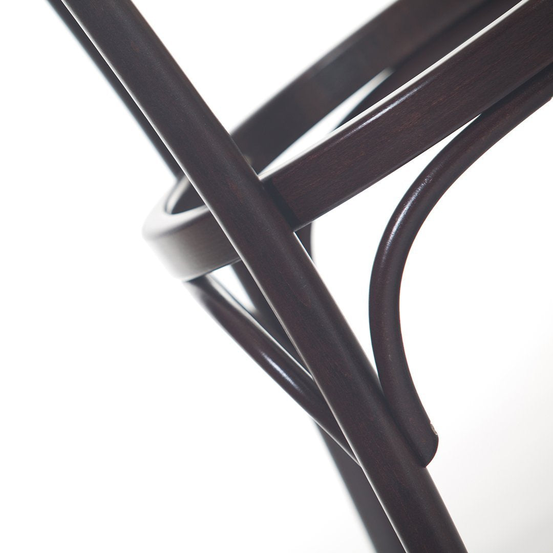 Dark brown curved wood chair design with smooth, elegant lines against a soft white background.