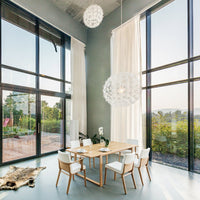 Elegant dining room featuring light wood table, white chairs, soft neutral walls, and sheer white curtains.