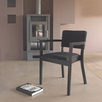 "Modern black chair with woven pattern, stylishly set against a warm beige background."