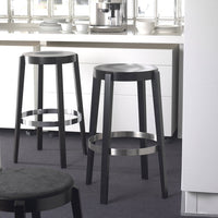 Black bar stools with sleek silver rings, featuring a minimalist design, set against a neutral kitchen backdrop.