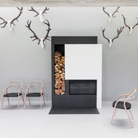 Modern fireplace in black and white, featuring stacked wood and minimalistic design. Elegant chairs with soft pink accents.