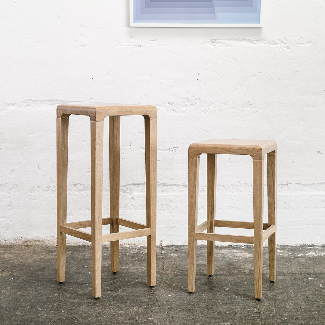 Light wood bar stools with a natural finish, featuring clean lines and a simple, modern design.