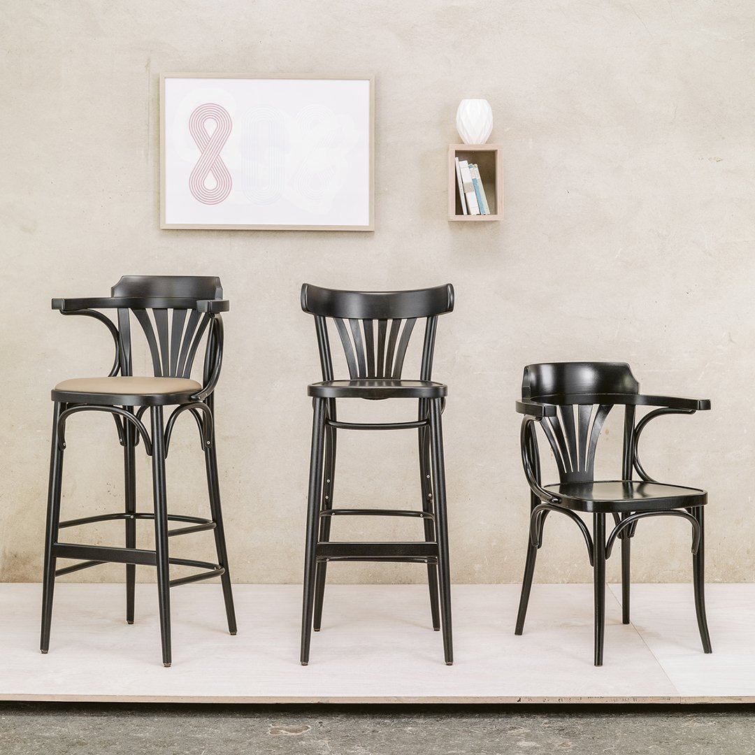 "Black wooden bar stools with sleek lines and curved backs, set against a neutral backdrop."