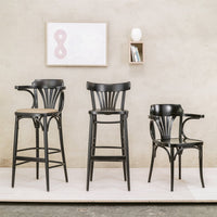 "Black wooden bar stools with sleek lines and curved backs, set against a neutral backdrop."