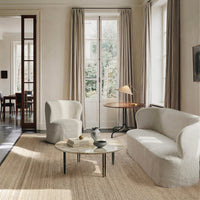 Cozy living room featuring soft beige and cream tones, with simple, modern shapes and a neutral textured rug.