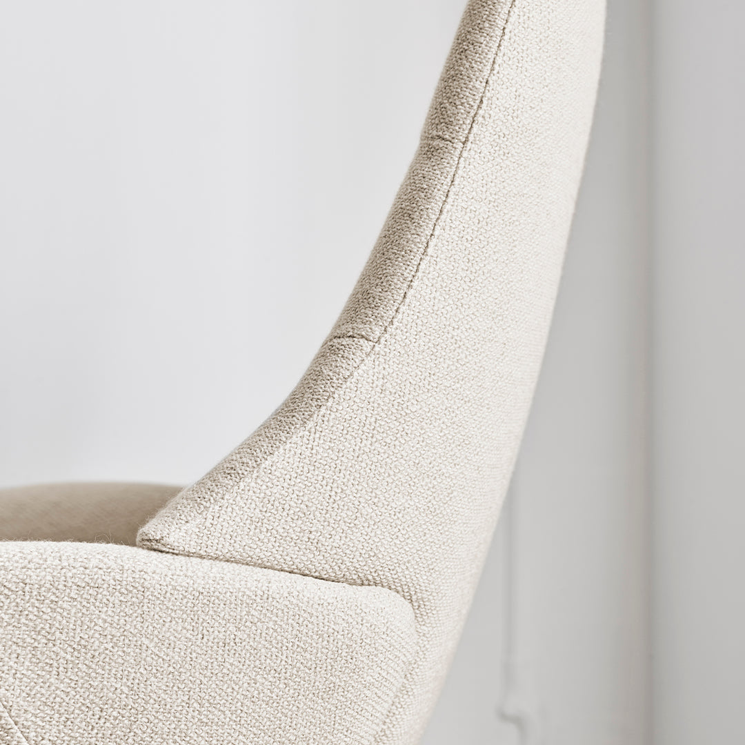 Beige upholstered chair with a textured fabric and a sleek, modern silhouette. Perfect for contemporary decor.