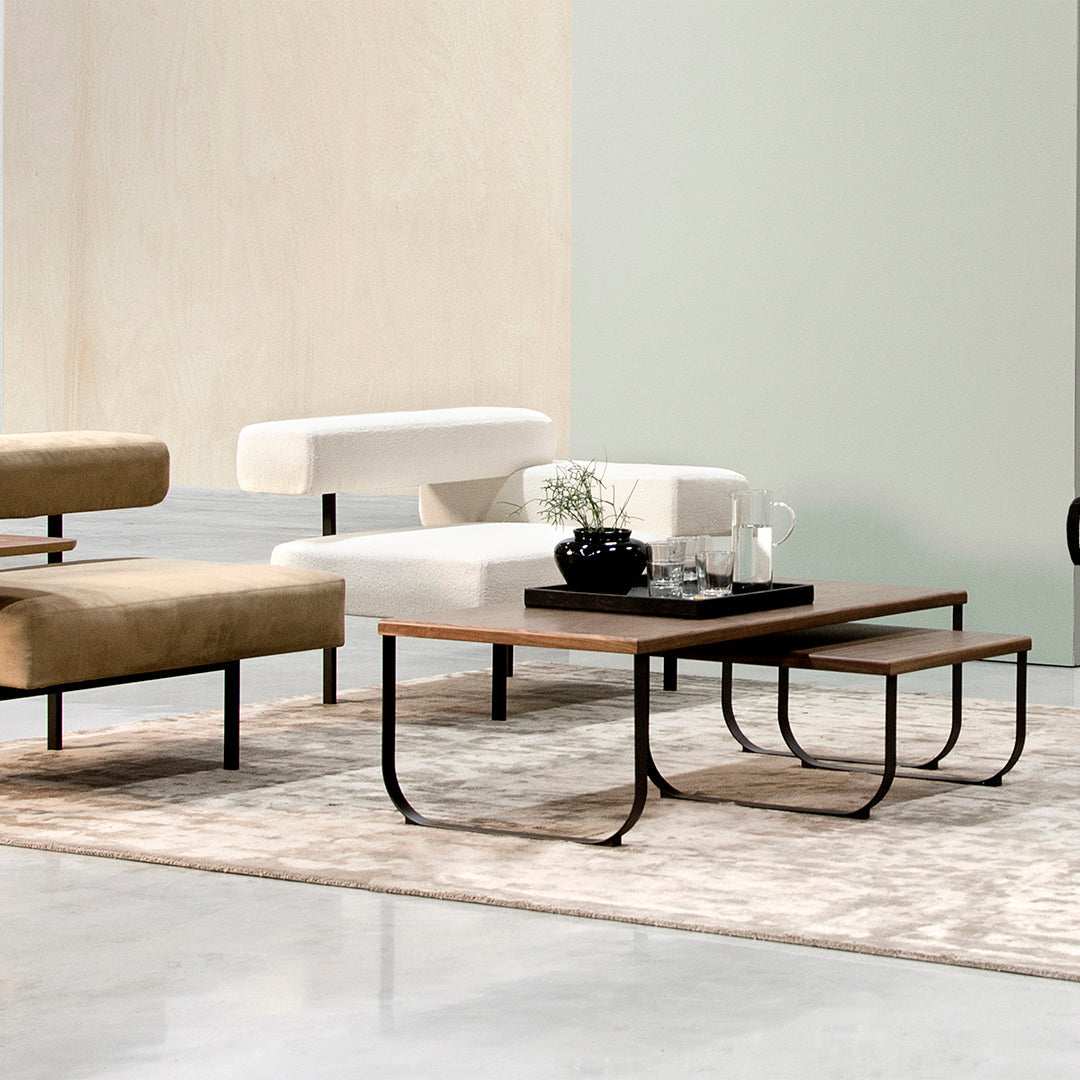 Beige and white furniture on a soft gray rug, with black accents and a mint green wall in the background.