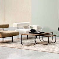 Beige and white furniture on a soft gray rug, with black accents and a mint green wall in the background.