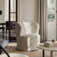 Cream-colored upholstered armchair with a rounded silhouette, soft texture, and subtle stitching detailing.